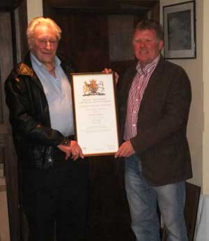 Mick Baker receiving his certificate of service from Coxswain Tom Clark