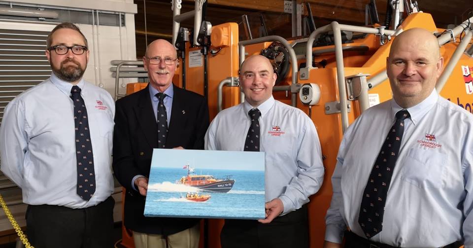Colin Woodhead receiving a picture from Lifeboat crew members photo Kay Jackson 